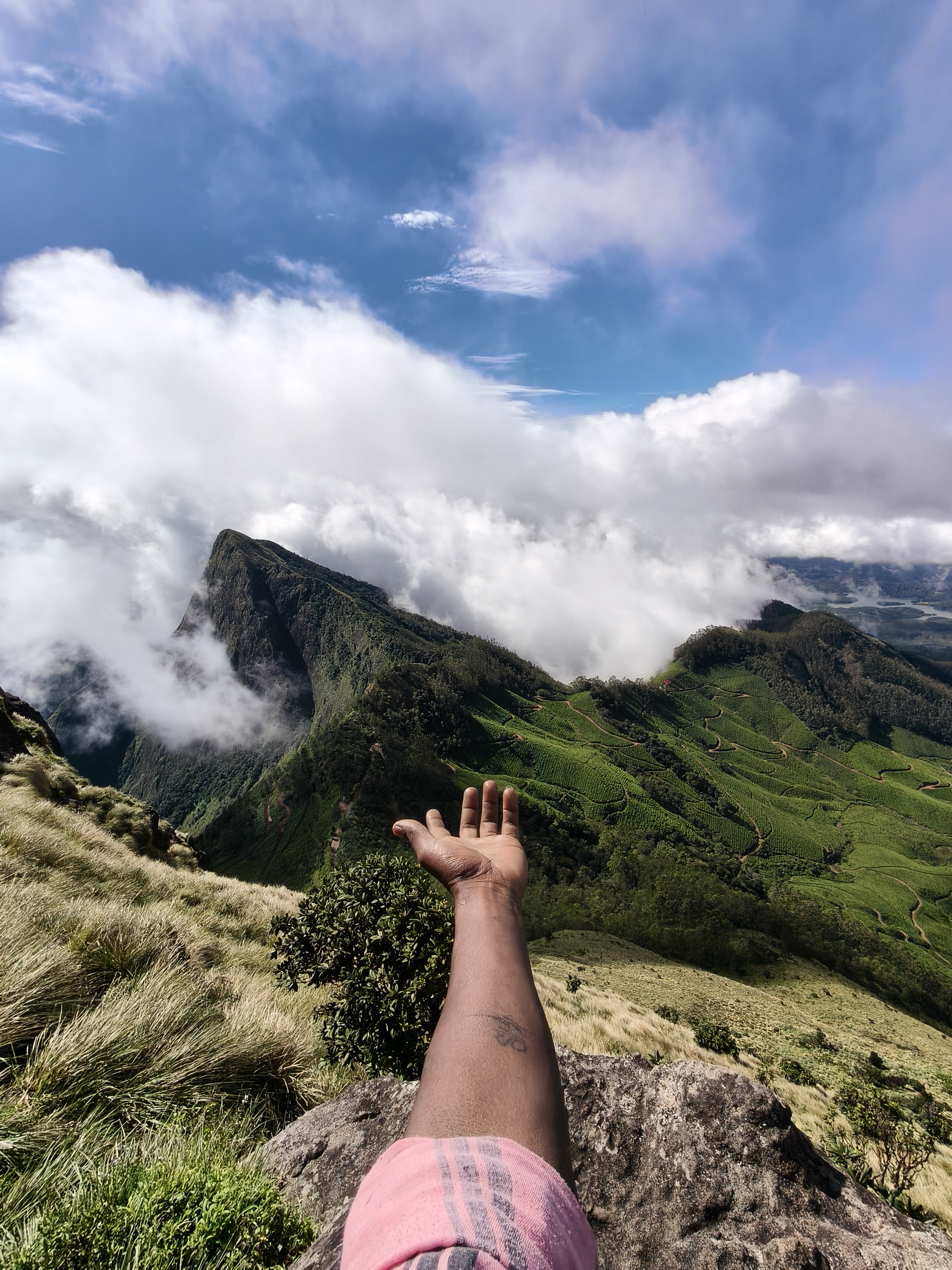 Kolukkumalai misty mountain valley with tea gardens and clouds rolling over cliffs